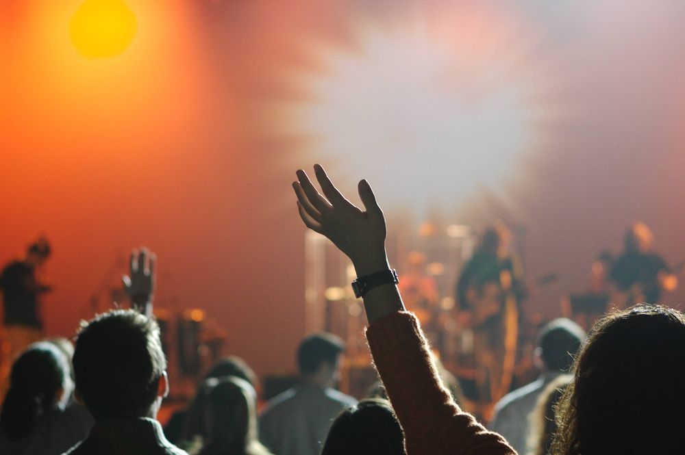 Una asamblea de oracion con muchos cristianos evangelicos levantando las manos